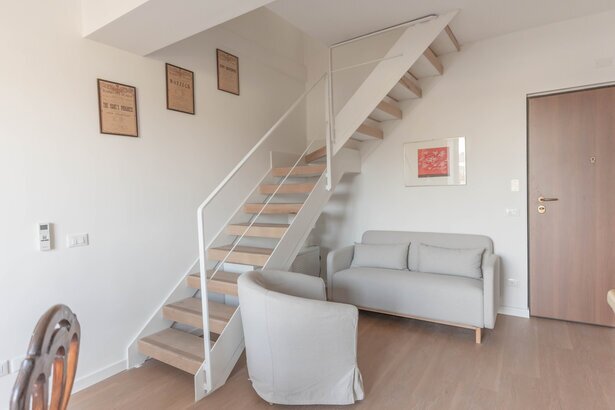 Area living elegante di un serviced apartment con dettagli curati e luce naturale.